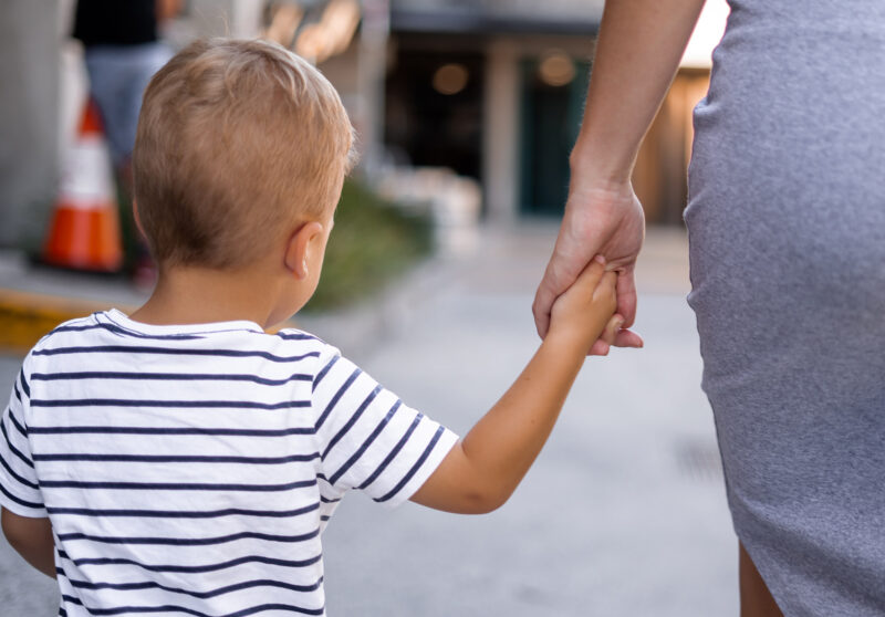 A child walking holding hands with woman